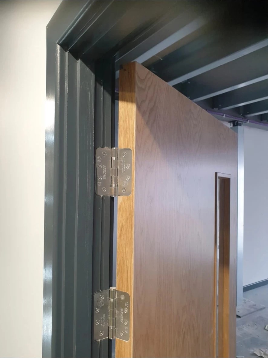 Fire-rated hinges fitted to an oak fire door in a painted frame